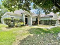 Charming single-story home with a manicured front yard and beautiful landscaping at 671 Carey Way, Orlando, FL 32825