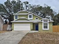 Charming two-story home with a white garage door and a blue front door framed by bright green walls at 101 Grand Junction Blvd, Orlando, FL 32835