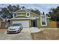 Charming two-story home with a well-maintained lawn, a driveway with a car, and a welcoming blue front door at 101 Grand Junction Blvd, Orlando, FL 32835