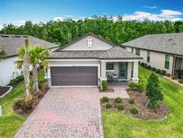 Beautiful single-story home with a well-manicured lawn and a welcoming covered entrance and a brick-paved driveway at 1029 Umbria Dr, Poinciana, FL 34759