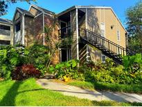 Inviting two-story home with lush landscaping, brick accents, and an exterior staircase at 2213 Metropolitan Way # 1318, Orlando, FL 32839