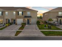 Charming townhome featuring a one-car garage, neutral-toned exterior, and well-maintained landscaping at 2302 Tay Wes Dr, St Cloud, FL 34771
