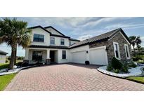 Elegant two-story home featuring a brick driveway, attached two-car garage and beautifully landscaped front yard at 2920 Agostino Ter, Kissimmee, FL 34746