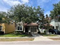 Charming home featuring a well-maintained lawn, mature trees, and a cozy two-car garage in a Gathering-friendly neighborhood at 2985 Banana Palm Dr, Kissimmee, FL 34747