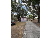 Cozy single-story home with a spacious driveway and mature trees providing shade at 3535 Island Oaks N, Lakeland, FL 33805