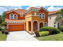 Charming two-story home with a tile roof, a two-car garage, and nicely landscaped front yard at 394 Orange Cosmos Blvd, Davenport, FL 33837