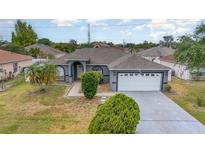 Charming single-story home with a well-maintained lawn and a two-car garage at 604 Kangaroo Dr, Poinciana, FL 34759