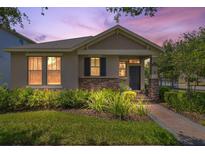 Charming single-story home with stone accents, manicured landscaping and a brick walkway leading to the front door at 8262 Bayview Crossing Dr, Winter Garden, FL 34787