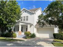 Charming two-story home with white siding, front porch, and manicured landscaping at 907 Pawstand Rd, Celebration, FL 34747