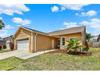 Charming one-story home with a two-car garage, well-maintained lawn, and beautiful landscaping at 1050 Dees Dr, Oviedo, FL 32765