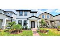 Charming two-story home with landscaped yard, healthy green grass and brick walkway at 12537 Encore At Ovation Way, Winter Garden, FL 34787