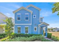Charming two-story blue home with white trim, shutters, and a manicured front yard at 1428 Reunion Blvd, Kissimmee, FL 34747