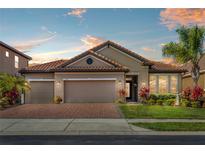 Charming home with a tile roof, brick driveway, and well-manicured landscaping at 1631 Nina Dr, Davenport, FL 33837