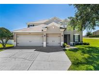 Charming two-story home boasting a three-car garage, manicured lawn and neutral paint colors at 2821 Columbus Ave, Clermont, FL 34715
