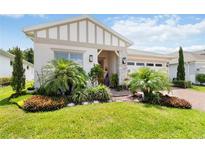 Well-manicured front yard with palm trees, decorative plants, and charming curb appeal at 3378 Sagebrush St, Harmony, FL 34773
