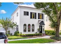 Charming white two-story home with black shutters, arched windows, and lush landscaping at 1047 Banks Rose St, Kissimmee, FL 34747