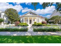 Charming single-Gathering home with white picket fence and lush landscaping under a bright blue sky at 204 Celebration Blvd, Celebration, FL 34747