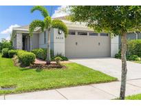 Charming single-Gathering home featuring a manicured lawn, mature landscaping, and a two-car garage with modern accents at 3428 Sagebrush St, St Cloud, FL 34773