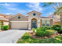 Charming single-story home with a well-manicured lawn, attached garage, and a decorative front entrance at 4416 Acorn Ct, Davenport, FL 33837