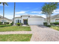 Charming single-story home featuring a brick driveway, two-car garage, and well-maintained landscaping at 4796 Cumbrian Lakes Dr, Kissimmee, FL 34746