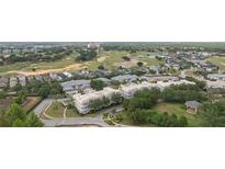 Beautiful aerial view of the condo community nestled among lush landscaping and a well-manicured golf course at 7509 Mourning Dove Cir # 303, Reunion, FL 34747