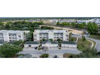 Scenic aerial view of condo buildings with private garages and lush landscaping in a well-maintained community at 7509 Mourning Dove Cir # 303, Reunion, FL 34747