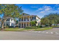 Charming two-story home boasts dual balconies, a manicured lawn, and mature trees at 7550 Gathering Dr, Reunion, FL 34747