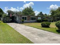 Charming single-story brick home with a covered parking area and well-maintained front lawn at 930 Aultman Rd, Kissimmee, FL 34744