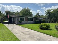 Charming single-story home featuring a well-maintained lawn and long driveway at 930 Aultman Rd, Kissimmee, FL 34744