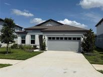 Charming one-story home featuring a two-car garage, well-maintained lawn, and beautifully landscaped front yard at 983 Silverlake Blvd, Lake Alfred, FL 33850