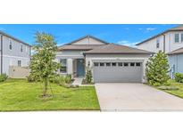 Charming single-story home featuring a well-manicured lawn, light gray siding, and a two-car garage at 983 Silverlake Blvd, Lake Alfred, FL 33850