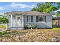 Charming exterior showcasing the white porch, complemented by black shutters and gray siding at 1024 Cohassett Ave, Lake Wales, FL 33853