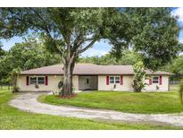 Charming ranch-style home featuring a lovely lawn and mature trees providing ample shade and curb appeal at 1055 N Chickasaw Trl, Orlando, FL 32825