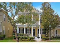 Charming two-story home with a welcoming front porch, pillars, and beautifully landscaped yard at 1115 Mosaic Dr, Celebration, FL 34747