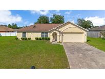Charming single-story home with a well-maintained lawn and attached two-car garage at 14091 Sw 32Nd Terrace Rd, Ocala, FL 34473