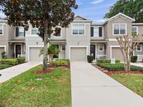Inviting townhome exterior with well-maintained landscaping and a private driveway at 1917 Compass Flower Way, Ocoee, FL 34761
