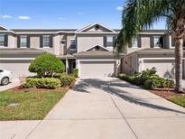 Charming townhouse featuring a well-manicured lawn and a two-car garage, perfect for modern living at 1936 Compass Flower Way, Ocoee, FL 34761