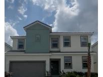 Two-story home featuring an attached garage, a neutral color scheme, and a well-maintained front yard with a palm tree at 2436 Rama Dr, Kissimmee, FL 34746