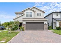 Charming two-story home featuring a two-car garage, and brick paver driveway and stone column accents at 2922 Crest Dr, Kissimmee, FL 34744