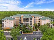 Attractive condo building features multiple floors and a large parking lot nestled near a lush forest at 3060 Pirates Retreat Ct # 309, Kissimmee, FL 34747