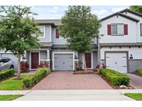 Charming townhomes featuring brick driveways, attached garages and colorful landscaping at 352 Smugglers Way, Apopka, FL 32712