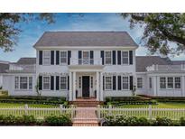 Charming two-story white home with black shutters and manicured landscaping offers timeless curb appeal at 423 Arbor Cir, Celebration, FL 34747