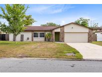 Charming single-story home with a well-manicured lawn, stone accents, and a two-car garage at 4412 Mesa Verde Dr, St Cloud, FL 34769