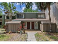 Inviting townhome exterior with a well-maintained lawn, mature trees, and a welcoming entryway at 5234 Eaglesmere Dr # D04, Orlando, FL 32819