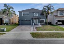 Charming two-story home featuring a brick driveway and lush landscaping at 5768 Los Palma Vista Dr, Orlando, FL 32837