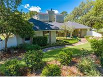 Charming home featuring lush landscaping, a winding walkway, and unique architectural details at 6464 Timberwind Pl, Orlando, FL 32818