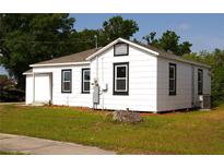 Exterior view of a white house with a green lawn and black trimmed windows at 709 28Th Nw St, Winter Haven, FL 33881