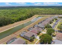 Beautiful aerial view of the home with a screened-in pool overlooking a canal and lush greenery at 8571 La Isla Dr, Kissimmee, FL 34747