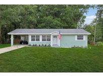 Charming one-story home featuring a well-manicured lawn and covered parking at 918 Louise Ln, Deland, FL 32720