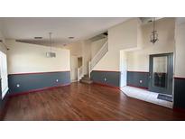 Bright living room boasts hardwood floors and staircase, enhanced with two-tone walls and a contemporary light fixture at 979 Hacienda Cir, Kissimmee, FL 34741